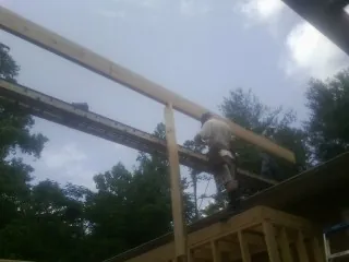 Carpenter setting a ridge beam over a new addition frame — Ice Dam Removal by Roofing Brothers in San Anselmo