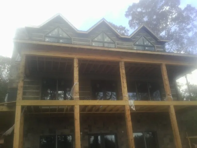 Dormers and porch framing on a large log home under construction — Roof Coating work by our crew in San Anselmo